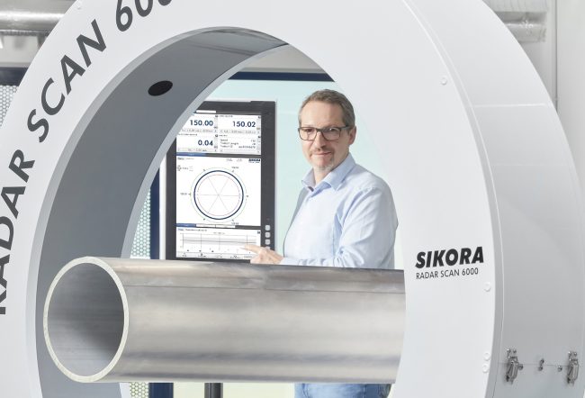 Das Messgerät Radar Scan 6000 von Sikora setzt auf Radartechnik. In der Maschine steht ein Mitarbeiter.