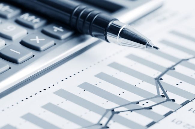 Das Bild zeigt ein Stillleben aus einem taschenrechner, einem Stift und einem Kurvenverlauf. Es steht symbolisch für eine Finanzmeldung der Swiss Steel Group.