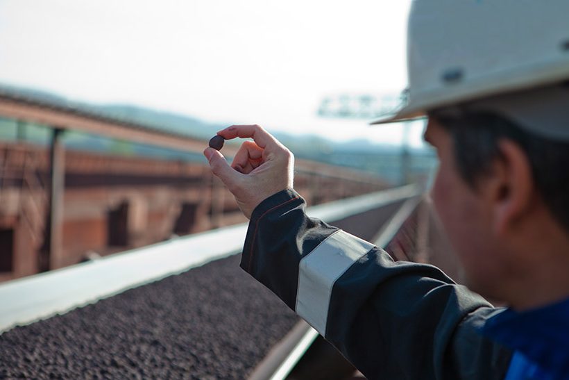 Mitarbeiter von Primetals Technologies begutachtet Eisenerz-Pellets