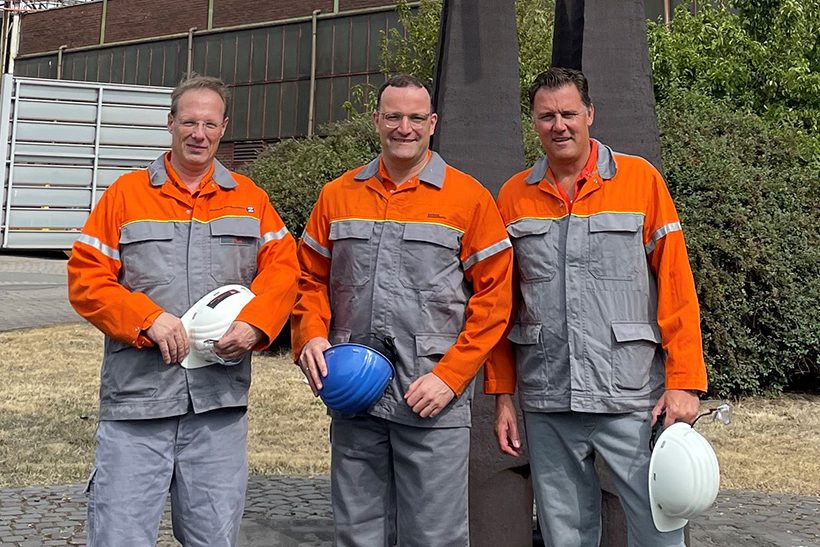 Jens Spahn mit blauem Helm, zu seiner linken steht CEO Frank Koch