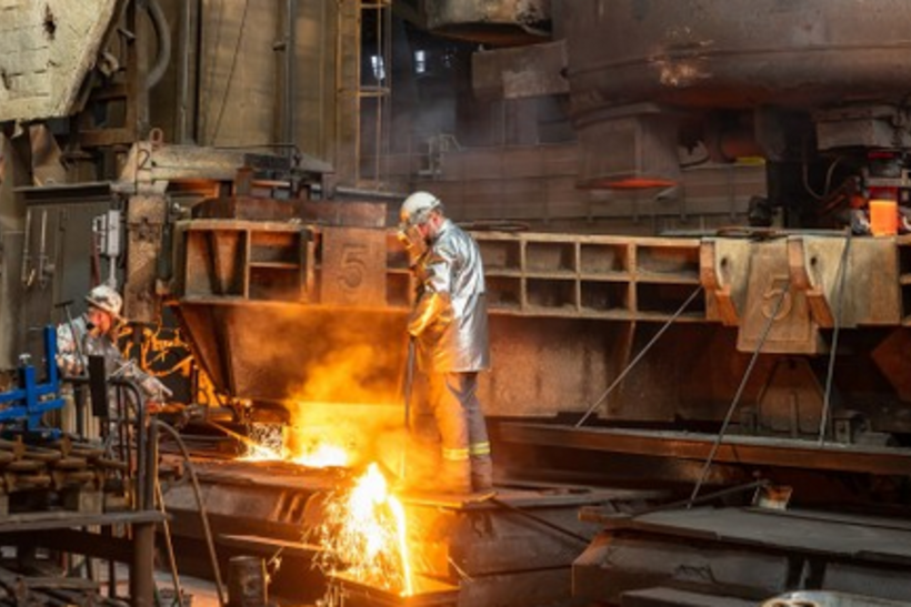 ArcelorMittal-stahlwerk-szene-transformationsgipfel-aufruf: Arbeiter in Schutzkleidung bei flüssigem Metall.