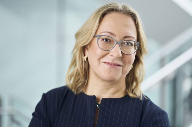 Das Porträtbild zeigt eine blonde Frau mit schulterlangen Haaren und einer Brille. Es handelt sich um Birgit Potrafki, die CFO der SZAG wird.