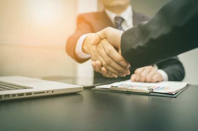Handschlag zwischen zwei Parteien bei Unternehmensverkauf (Symbolbild)