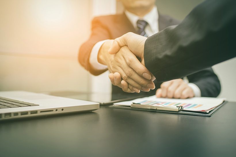 Handschlag zwischen zwei Parteien bei Unternehmensverkauf (Symbolbild)