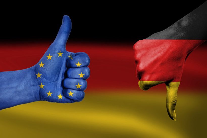 Das Bild zeigt zwei bemalte Fäuste, die jeweils den Daumen ausstrecken. Auf der linken Seite ist eine blaue Hand mit der EU-Flagge zu sehen, die den Daumen nach oben reckt und auf der rechten Seite, die Hand ist schwarz-rot-gold, geht der Daumen nach unten. Im Hintergrund ist die Flagge Deutschlands zu sehen. Die rechte Hand steht dabei symbolisch für die WV Stahl und die linke hand für die EU-Kommission.