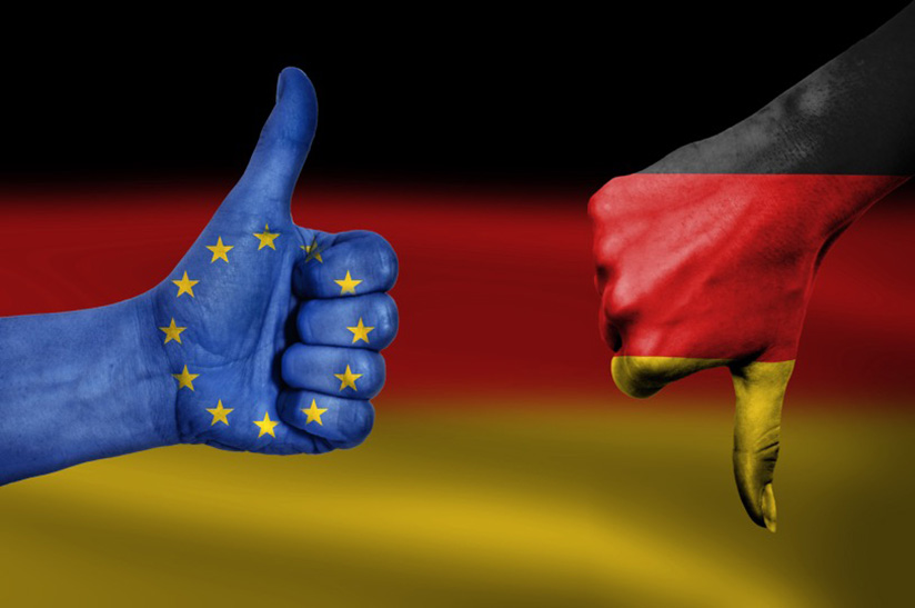 Das Bild zeigt zwei bemalte Fäuste, die jeweils den Daumen ausstrecken. Auf der linken Seite ist eine blaue Hand mit der EU-Flagge zu sehen, die den Daumen nach oben reckt und auf der rechten Seite, die Hand ist schwarz-rot-gold, geht der Daumen nach unten. Im Hintergrund ist die Flagge Deutschlands zu sehen. Die rechte Hand steht dabei symbolisch für die WV Stahl und die linke hand für die EU-Kommission.