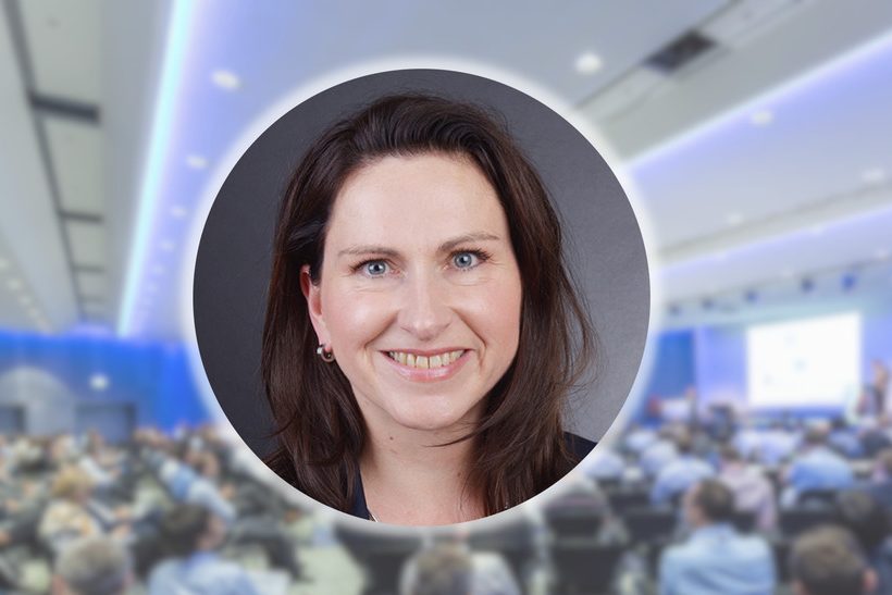 Das Bild zeigt mittig den Kopf einer Frau (Dr. Stefanie Brockmann, Stahlinstitut VDEh). Im Hintergrund ist unscharf ein Vortrag von der Fachkonferenz ESTAD 2019 zu sehen.