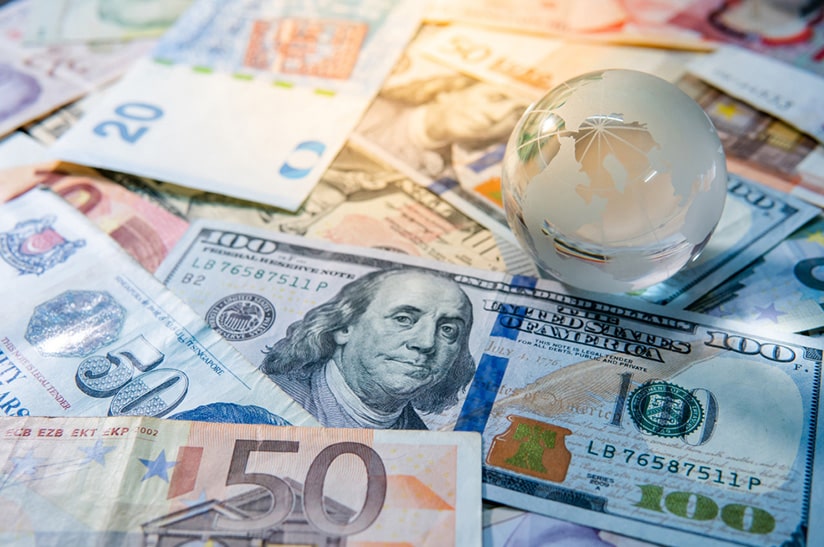 Globus mit verschiedenen Währungen, Fokus auf Eurozone-Investitionen (Symbolbild)