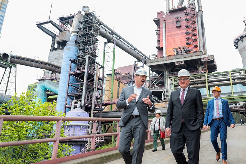 Das BIld zeigt im Hintergrund eine technische Anlage und im Vordergrund zwei Männer im Anzug – links Bernhard Osburg von thyssenkrupp Steel Europe, rechts Bundespräsident Frank-Walter Steinmeier.