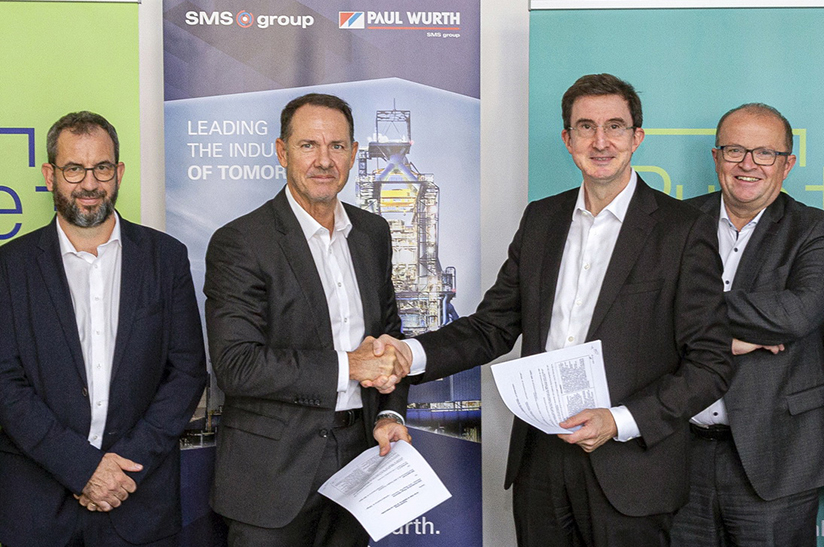 Dillinger_230901 (web) Das Bild zeigt vier weiße Männer im Sakko, die beiden ind er Mitte schütteln sich die Hände und halten jeweils einen Vertrag in der Hand. Es handelt sich um Personen von den Unternehmen SMS digital, Paul Wurth und Dillinger / saarstahl-werk-voelklingen-uebernahme-liberty-ascoval-hayang, die den Hochofenbetrieb optimieren wollen.