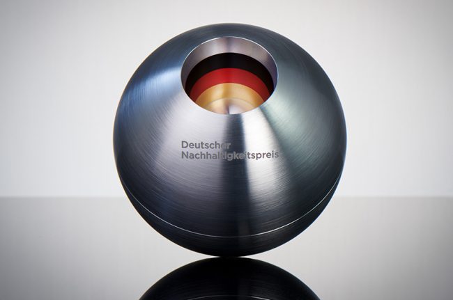 Pressefoto_Deutscher_Nachhaltigkeitspreis_Preisstatuette_Fotocredit_Frank_Fendler_2021 (web) Das Bild zeigt eine Edelstahlkugel, die beim Deutschen Nachhaltigkeitspreis an den Sieger verliehen wird. Die Gravur lautet: Deutscher Nachhaltigkeitspreis.
