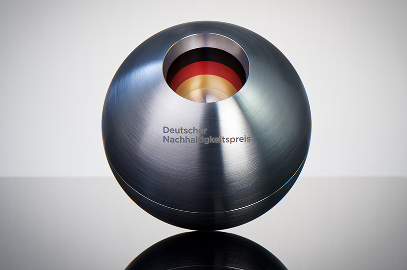 Pressefoto_Deutscher_Nachhaltigkeitspreis_Preisstatuette_Fotocredit_Frank_Fendler_2021 (web) Das Bild zeigt eine Edelstahlkugel, die beim Deutschen Nachhaltigkeitspreis an den Sieger verliehen wird. Die Gravur lautet: Deutscher Nachhaltigkeitspreis.