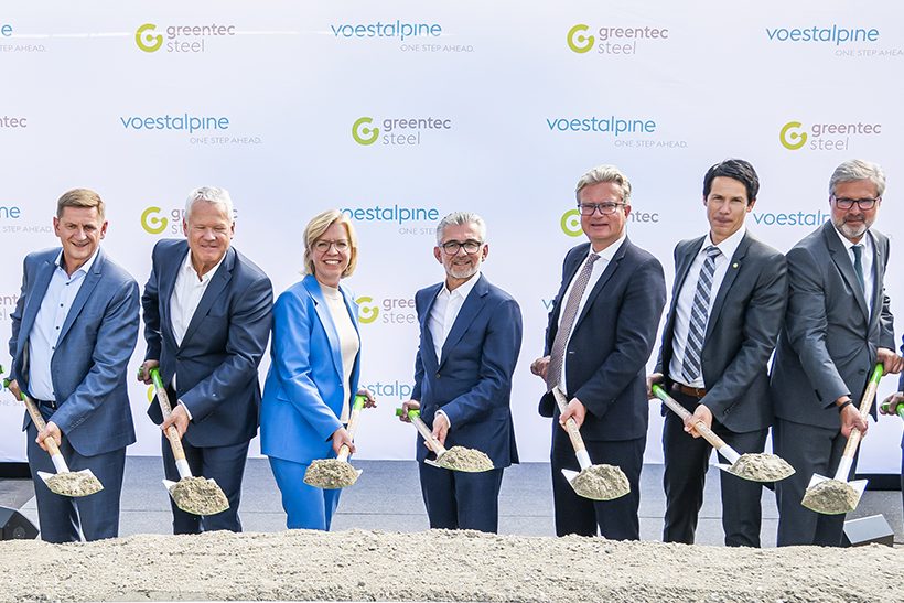 Das Bild zeigt sechs Männer und eine Frau, in der Mitte der CEO von Voestalpine, beim traditionellen ersten Spatenstich für das Projekt Greentec Steel. Alle Personen halten einen Spaten in der Hand, auf dessen Blatt sich Erde befindet.