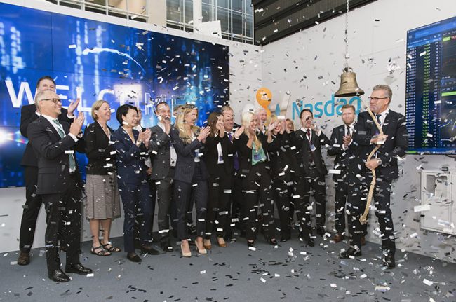 baa3460bba2d1f77_org (web) Das Bild zeigt das Führungspersonal von Alleima im Rahmen des Börsengangs. Der CEO schlägt eine Glocke, eine Gruppe Menschen applaudiert und Konfetti fliegt.