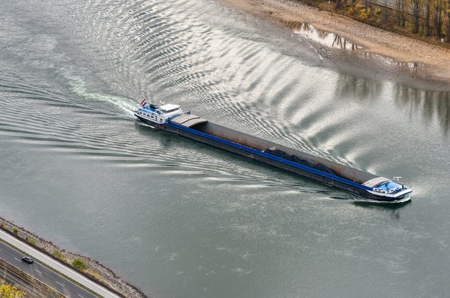 Inland,Coal,Freighter,With,Reduced,Shipload,On,River,Rhine,With Das Schiff zeigt einen Kohlefrachter auf dem Mittelrhein bei Bingen bei niedrigem Wasserstand. Die Stahlindustrie ist auf einen schiffbaren Fluss angewiesen.