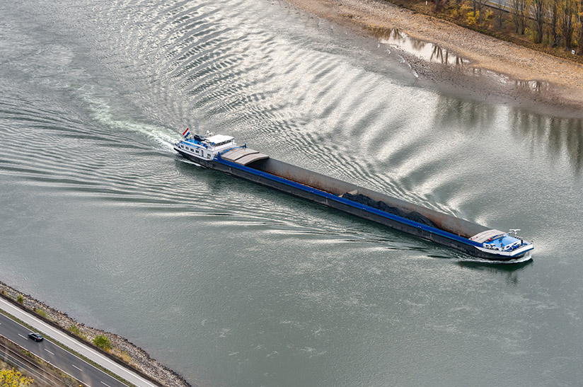 Inland,Coal,Freighter,With,Reduced,Shipload,On,River,Rhine,With Das Schiff zeigt einen Kohlefrachter auf dem Mittelrhein bei Bingen bei niedrigem Wasserstand. Die Stahlindustrie ist auf einen schiffbaren Fluss angewiesen.