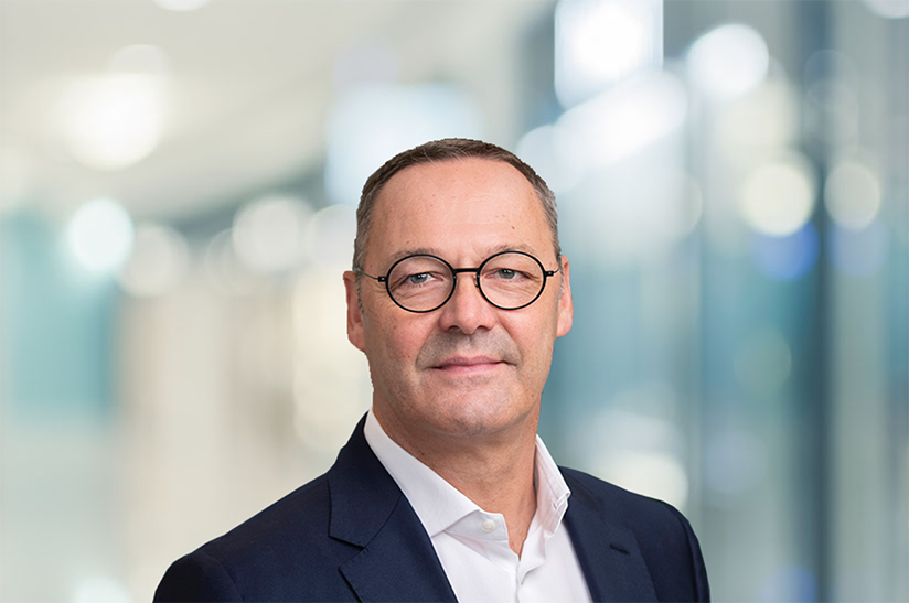 Das Bild zeigt ein Porträt von Bernhard Osburg, der eine Doppelfunktion als Chef von Thyssenkrupp Steel Europe und Präsident der Wirtschaftsvereinigung Stahl einnimmt. In letzterer äußert er sich auch zu aktuellen politischen Themen wie etwa einem EU-USA-Gipfeltreffen zu Stahl im Oktober 2023.