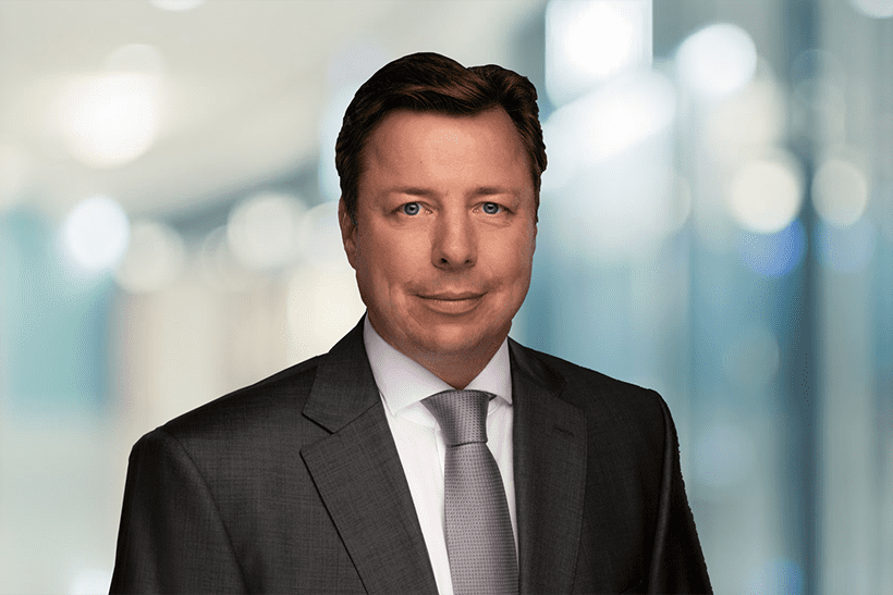 das Bild zeigt vor einem unscharfen Hintergrund das Porträt eines weißen Mannes im Anzug. Es handelt sich dabei um Jan Weckes, den neuen Geschäftsführer von Schade Lagertechnik.