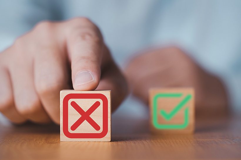Das Bild zeigt eine Hand, die einen Stein mit einem roten X nach vorne schiebt. Das steht sinnbildlich für die negative Prognose zur Stahlerzeugung in Deutschland.