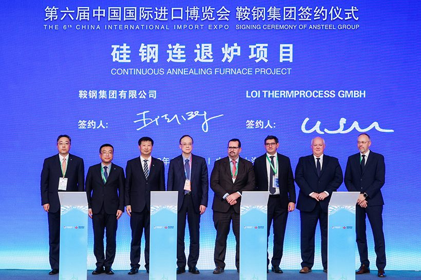 Das Foto zeigt acht Führungskräfte von Tenova LOI Thermprocess und Ansteel auf einer Bühne