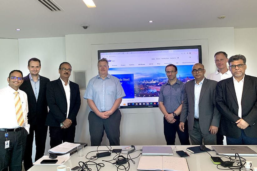 Primetals modernisiert für JSW Steel in Mingo Junction, Ohio. Das Foto zeigt acht männliche Mitglieder aus den Projektteams aus beiden Unternehmen.