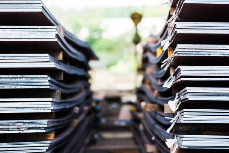 Gestapelte Stahlplatten von Ilsenburger Grobblech im Lager. Das Bild zeigt ein Stahllager. ASS Stahlservice betreibt vergleichbare.