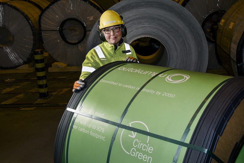 Das Bild zeigt im Vordergrund einen Coil Circle Green Edelstahl von Outokumpu. Dahinter steht eine Person mit Schutzkleidung.