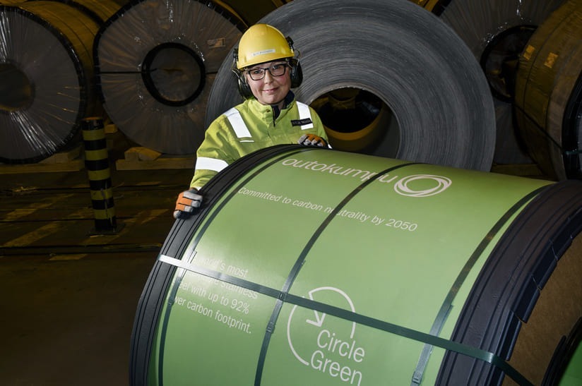 Das Bild zeigt im Vordergrund einen Coil Circle Green Edelstahl von Outokumpu. Dahinter steht eine Person mit Schutzkleidung.