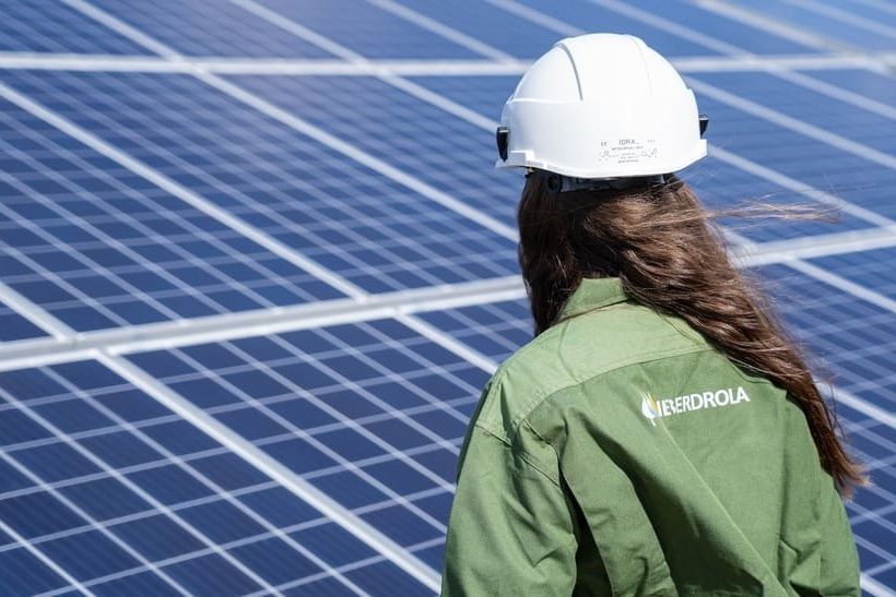 Iberdrola Deutschland baut sein hiesiges Geschäft aus. Das Foto zeigt eine Mitarbeiterin von hinten, die vor Solaranlagen steht.