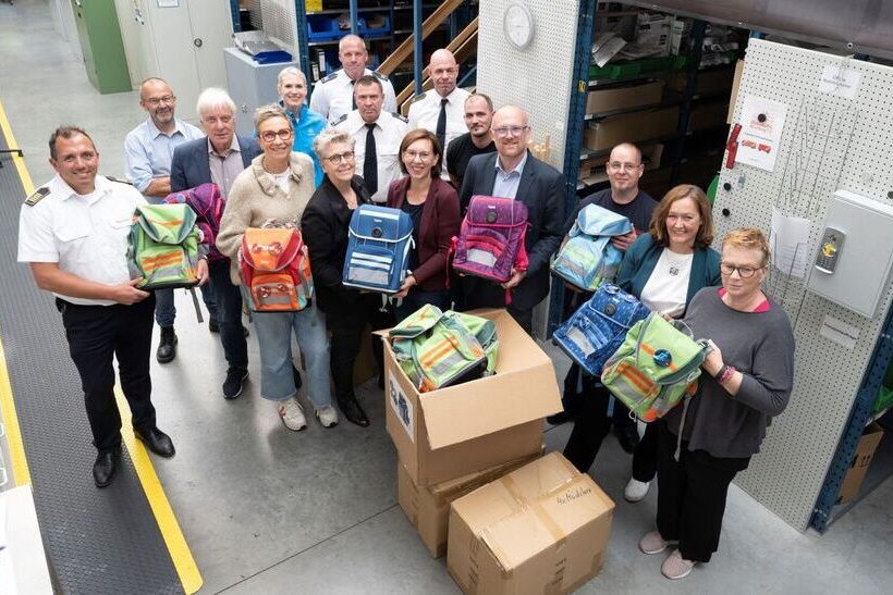 Gruppenbild Schulranzenprojekt von thyssenkrupp Steel in Zusammenarbeit mit dem Lions Club Duisburg-Concordia, dem Dezernat für Bildung, Arbeit und Soziales der Stadt Duisburg sowie der Feuerwehr. V.l.n.r: Oliver Tittmann, Amtsleiter Feuerwehr Duisburg; Klaus-Peter Müller, Dezernat für Bildung, Arbeit und Soziales, Stadt Duisburg; Hans-Martin Kokoschka, Präsident Lions Club Duisburg-Concordia; Elke Kirsch, Lions Club Duisburg-Concordia; Anna Benk, thyssenkrupp Steel Europe AG; Andrea Neubauer, Lions Club Duisburg-Concordia; Tobias Hintze, Sachbearbeiter Beschaffung Feuerwehr Duisburg; Konrad Dammeyer, stellv. Sachgebietsleiter Feuerwehr Duisburg; Christina Aumann, thyssenkrupp Steel Europe AG; Björn Gehre, Abteilungsleiter Feuerwehr Duisburg; Pascal Oberreich, TDL; Sören Link, Oberbürgermeister; Philippe Lambrecht, TDL; Nicole Sommer, Hüttenhelden e. V.; Katrin Kammann, DRK Schulsozialarbeiterin
