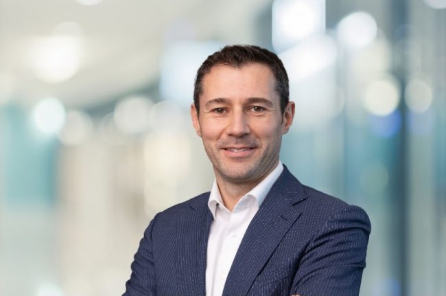 Das Bild zeigt ein Porträt von Tobias Trautmann. Er ist neuer Geschäftsführer von Vollmer Werke Maschinenfabrik. Der Hintergrund ist unscharf.