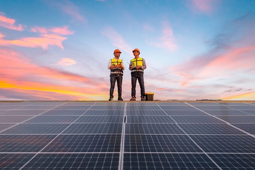 DasBild zeigt zwei Ingenieure, die augenscheinlich auf einem Dachfirst stehen. Vor ihnen sind Richtung Boden führende Solarpanel zu sehen. DasBild steht symbolisch dafür, dass sich die GMH Gruppe jetzt der SBTi angeschlossen hat.