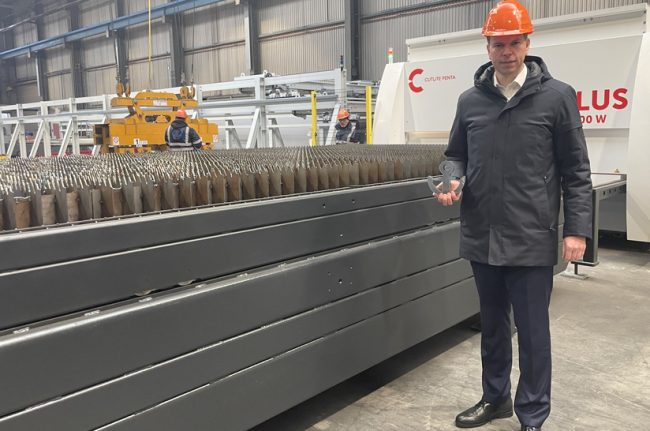 Auf dem Bild ist die neue Laserschneideanlage und der Geschäftsführer Felix Schmitz von Kloeckner Metals Germany zu sehen.
