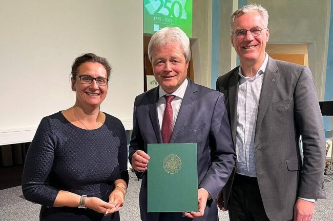 Dipl.-Ing. Ulrich Grethe (Mitte) hält die Urkunde für seine Ehrendoktorwürde in der Hand.