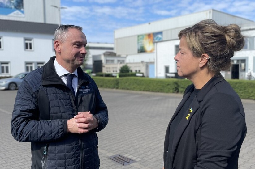 Das Bild zeigt Dirk Howe von der Siempelkamp Giesserei und Wirtschaftsministerin Mona Neubaur