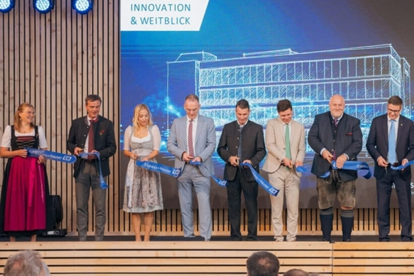 Das neue Temperaturmesstechnik-Zentrum von Endress+Hauser in Nesselwang (Zeichnung im Hintergrund) bietet eine Nutzfläche von 3.500 Quadratmetern und wurde traditionell mit einem Scherenschnitt eröffnet.