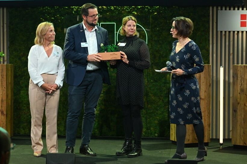 Kai Holzmüller, Direktor Personal und Sarah Lippert, Teamleiterin Marketing und Kommunikation, nehmen für Feralpi Stahl den Sustainable Impact Award 2025 entgegen.