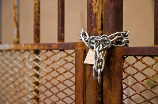 Thyssenkrupp Steel Europe sperrt Thyssenkrupp Electrical Steel in Gelsenkirchen-Schalke zu. Das Bild zeigt ein verrostetest Gitter, das mit einem neuen Schloss abgesperrt ist.