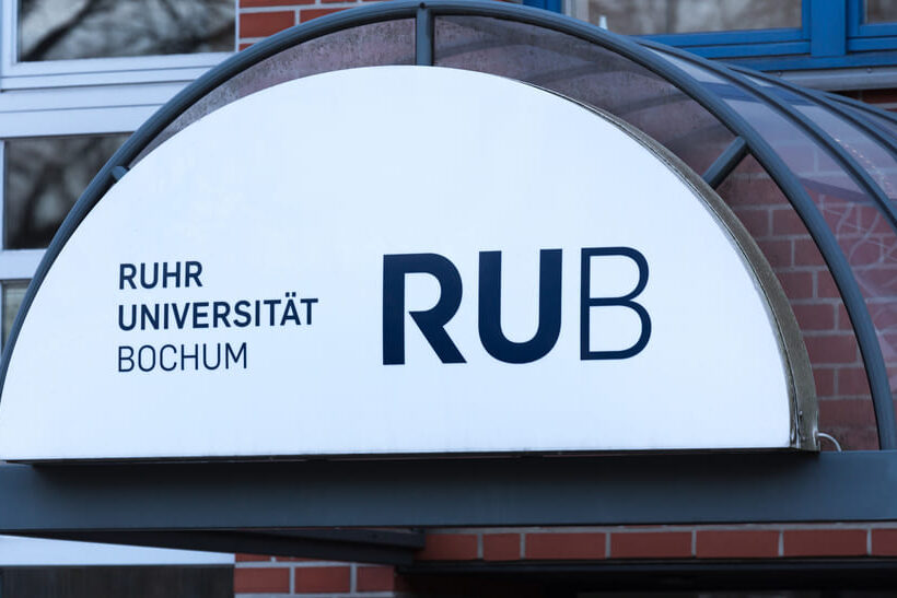 Das Bild zeigt ein Logo der RUB Ruhr Universität Bochum über einer Eingangstür.