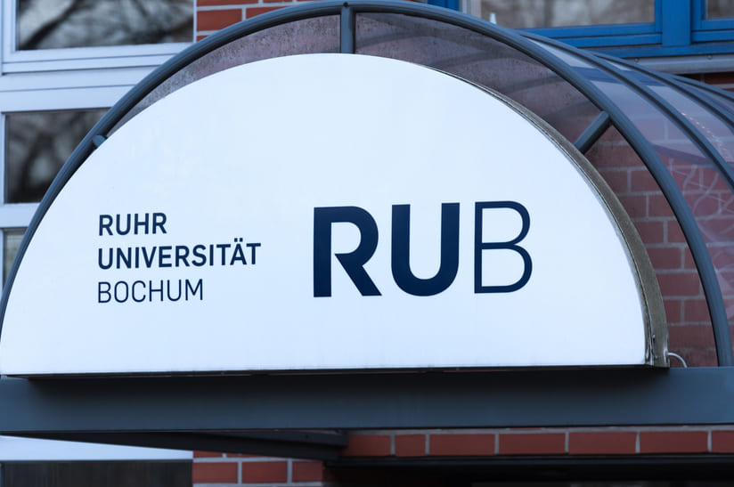 Das Bild zeigt ein Logo der RUB Ruhr Universität Bochum über einer Eingangstür.